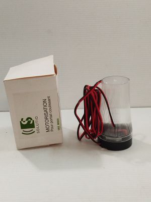une boîte et un verre posés sur une table, avec un cordon rouge