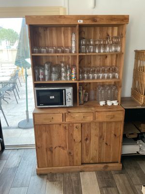 a wooden cabinet with a microwave on top of it
