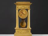une horloge en or posée sur une table blanche