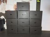 several black boxes stacked on top of each other in a room