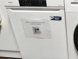 une photo d'une machine à laver blanche dans une cuisine