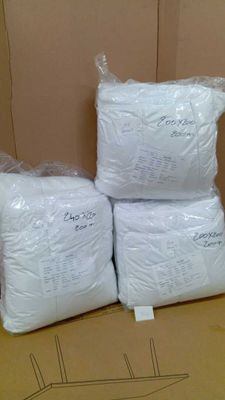 three bags of white pillows sitting on top of a cardboard box