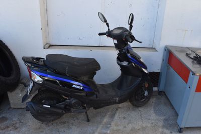 un scooter garé à côté d'un pneu