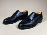 a pair of black leather shoes on a white surface