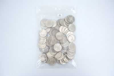 un sac rempli de pièces d'argent posé sur une surface blanche