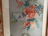 une photo d'une photo représentant un oiseau et des fleurs, dans un cadre