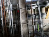 a room with a bunch of metal pipes and a ladder