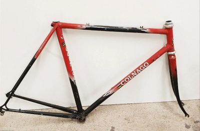 une photo d'un vélo rouge et noir appuyé contre un mur blanc