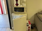 a small refrigerator in the corner of a room next to a couch
