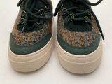 the shoes are brown and green with black laces on them