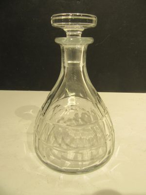 une bouteille en verre transparent munie d'un bouchon, posée sur une table