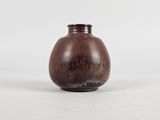 a small brown vase sitting on a white surface