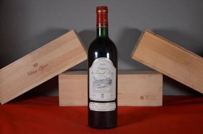 a bottle of wine sitting on a table next to two wooden boxes
