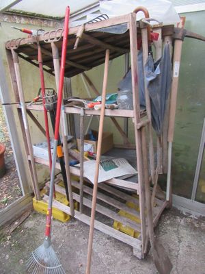 une petite remise dans laquelle se trouvent une pelle et un râteau
