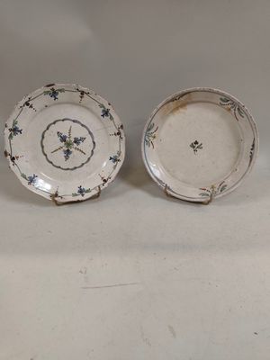 two plates with blue and white designs on them sitting on a white surface