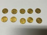 a bunch of gold coins sitting on top of a white table