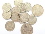 some coins are sitting on a white surface with a white background