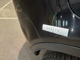 a sticker on the back of a car that is parked in a parking lot