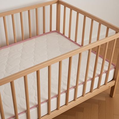 un lit de bébé avec un matelas et un oreiller à l'intérieur