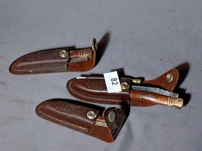 three leather sheaths with a knife on top of them on a table