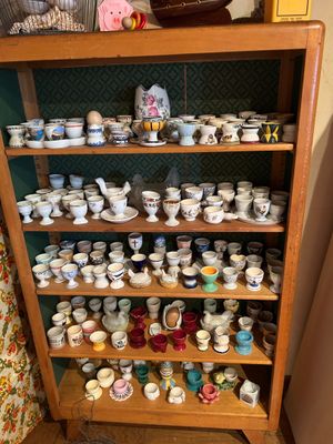 il y a beaucoup de tasses et de soucoupes sur les étagères de cette pièce
