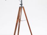 un télescope en bois monté sur un trépied, devant un fond blanc