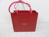 a red bag with a pink handle sitting on a white surface