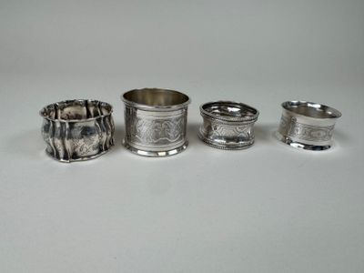 quatre serviettes et tasses argentées posées sur une surface blanche