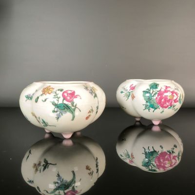 pair of chinese porcelain bowls with floral designs on them on a table