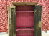 an old wooden cabinet with a door open on the floor
