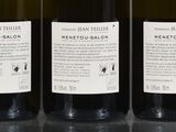 three bottles of wine are lined up on a table