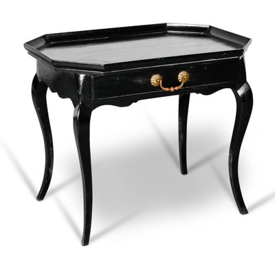 une table noire surmontée d'un tiroir, posée sur une surface blanche