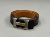 a close up of a belt with a metal buckle on a white surface