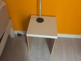 a small table with a lamp on it in the corner of a room