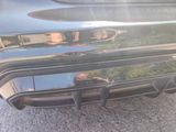 a reflection of a man in a mirror on the rear end of a car