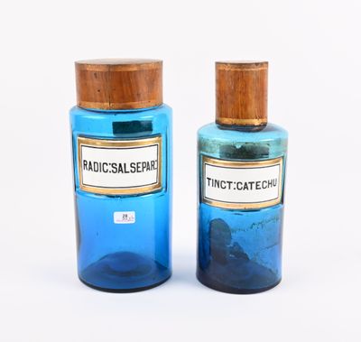 paire de deux bouteilles en verre bleues avec des couvercles en bois, posées sur une surface blanche