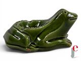 a green ceramic frog sitting on top of a bowl