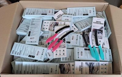 a cardboard box filled with scissors and a bunch of coupons