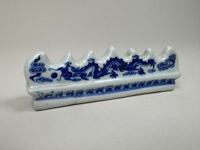 un plat en forme de dragon bleu et blanc posé sur une table blanche