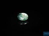 a close up of a green jade stone on a black surface
