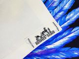 une enveloppe blanche sur laquelle est posée une plume bleue