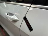 a sticker on the door handle of a white car