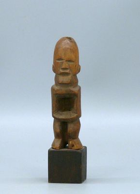 une petite statue en bois représentant un bébé tenant un livre