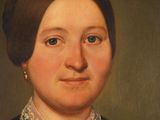 portrait of a woman in a black dress with a necklace and earrings