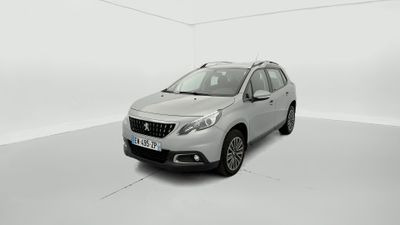 Une voiture argentée est garée dans une pièce blanche au sol blanc.