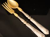two forks and spoons are sitting on a black surface