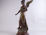 an antique bronze statue of a woman holding a bird on a wooden base