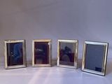 three silver picture frames with a man taking a picture of them