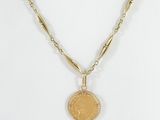 a close up of a necklace with a coin on a chain