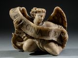statue d'un ange tenant un rouleau sur lequel est inscrit le mot « paix »